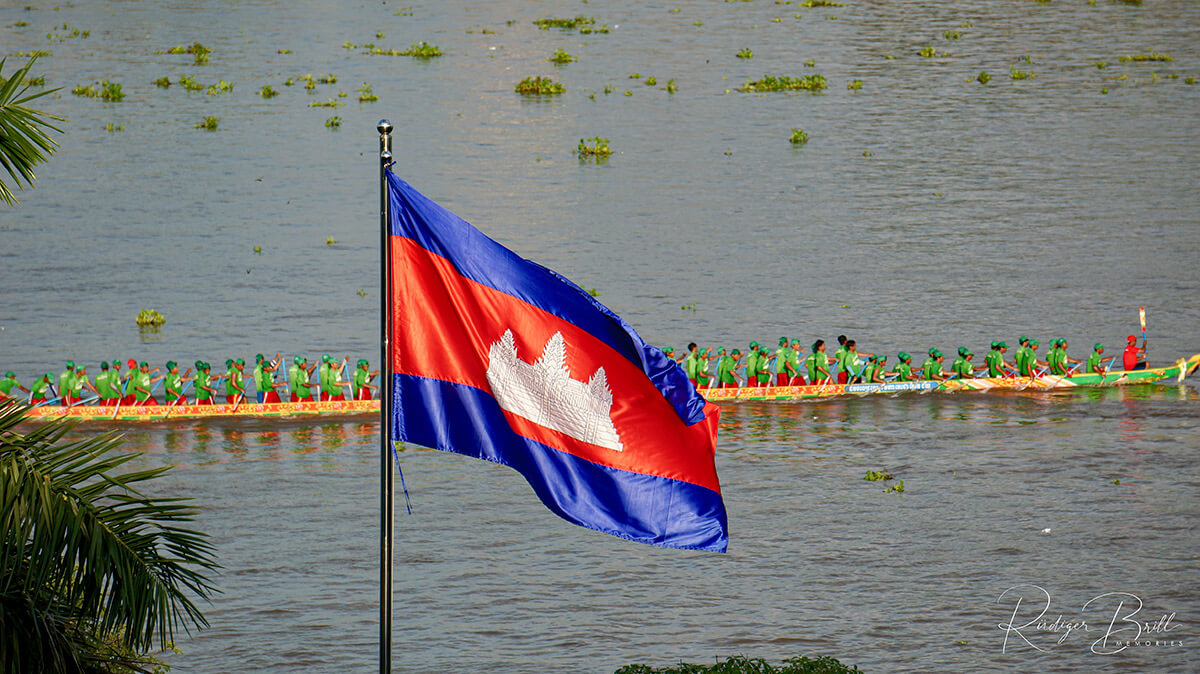 Ein Drachenboot mit 70 Ruderern in grüner Kleidung, das am Wettrennen bim Bon Om Touk, dem  Wasserfest in Phnom Penh, teilnimmt.